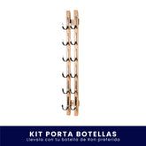 Organizador vertical de pared fabricado en madera con ganchos metálicos para colgar botellas, sobre fondo blanco. En la parte inferior incluye un banner azul con el texto "Kit Porta Botellas Llévalo con tu botella de Ron preferida".