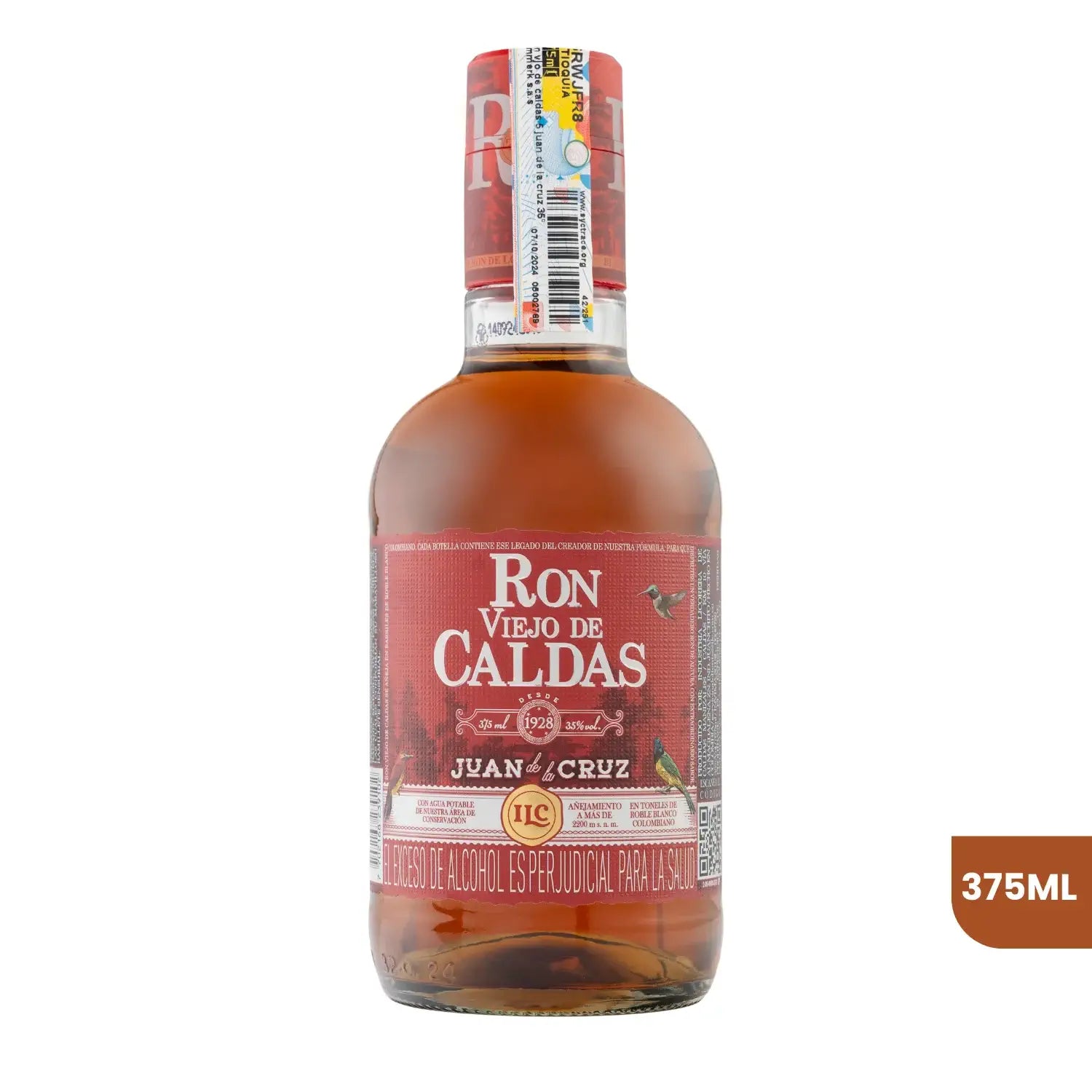 Botella de Ron Viejo de Caldas Juan de la Cruz de 375ml sobre fondo blanco. La botella de cristal muestra el licor ámbar y una etiqueta distintiva en tonos rojizos y ocres, con el logo de la marca e ilustraciones de aves típicas.